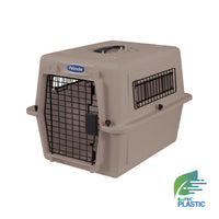 The Petmate Traveler - Ultra Vari Kennel is a tan, hard-sided pet carrier with black wire doors, side vents, a top handle, and displays the Petmate label plus an EcoTEC Plastic logo in the bottom right corner.