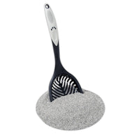 The Petmate Ultimate Litter Scoop, designed with a paw print pattern and an extra-long handle, stands out in a pile of finely textured gray litter. This essential cat cleaning tool efficiently gathers every bit as it fills the scoop.
