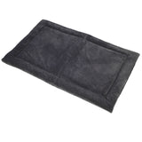 The Petmate Kennel Mat is a soft, rectangular, dark gray pet bed with a plush mattress and slightly raised edges. Its non-skid bottom ensures comfort and security for your furry friend. It sits elegantly on a white background.