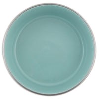 A turquoise round ceramic plate with a smooth surface and raised rim pairs elegantly with Petmates rust-resistant stainless steel bowls for a sophisticated table setting.