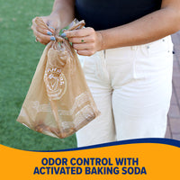 A person holds an Arm & Hammer Swivel Bin Pet Waste Bag in one hand while closing it with the other. The brown plastic bag displays branding and is ideal for pet waste management, featuring Odor Control with Activated Baking Soda.