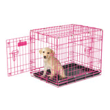 A small puppy sits inside a Petmate 2 Door Wire Puppy Crate with the door open. The pink crate is ideal for house training, resting on a black base, as the puppy looks towards the camera.