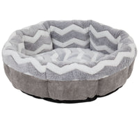 The SnooZZy Round Shearling Bolster Dog Bed by Snoozzy, in gray and white, features a zigzag pattern, plush fabric, and raised sides for comfort. Designed for aging pets, it has a non-skid bottom to ensure stability and safety.