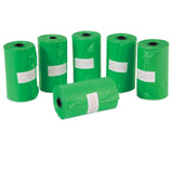 Six green rolls of Arm & Hammer Cornstarch Waste Bags are shown with five upright and one horizontal. Each roll features a white label with a red arrow pointing right, making them perfect for eco-friendly pet supplies.