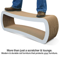 A confident person stands on the PetFusion Jumbo Cat Scratcher Lounge, showcasing its durability with its curved sides. Text below reads, Pet Fusion: More than just pet furniture—a modern, durable solution that protects your furniture.