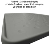 Close-up of a gray PetFusion Tough Grip Dog Food Mat featuring a 0.5-inch raised lip. The anti-slip surface is covered with raised dots. Text above reads, Raised 1/2 inch lip to contain food and water that escapes your dog or cats bowl, by Pet Fusion.