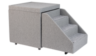 The PetFusion Multi-Purpose Pet Stairs, in premium gray with three steps and a textured fabric for durability, sits beside a soft cube-shaped ottoman, allowing pets to access higher surfaces safely.